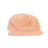 Pink cap with a logo on a black surface