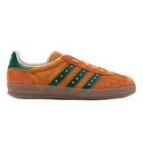 Orange Adidas sneaker with green stripes on a white background